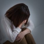 吐き気をおさえる女性